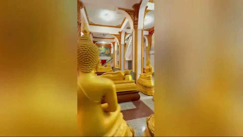 Golden Buddhas among white and gold columns inside the hall.