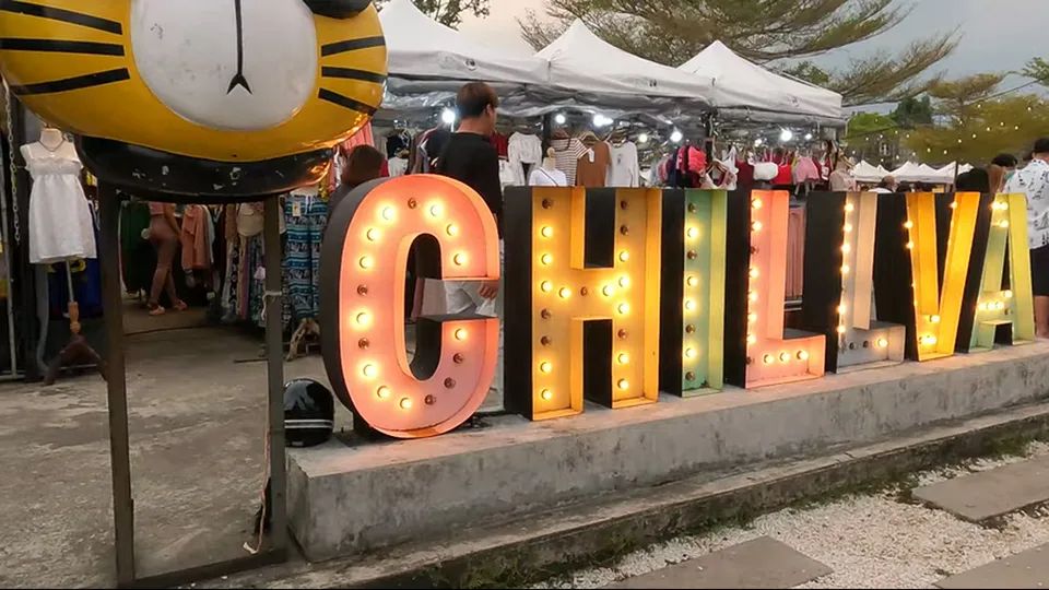 Lit spirit shrines between clothing stalls at Chillva Market